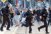 La policía alemana cruzando la calle en Chemnitz durante la polémica manifestación de caza de extranjeros.  /-ANDREAS SEIDEL