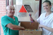Un voluntario entrega al personal de Asbem parte de los bolígrafos y material de escritura recolectados para la campaña.-ECB