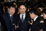 El heredero de Samsung, Lee Jae-Yong (centro), abandona el tribunal que ha ordenado su arresto, este viernes en Seúl.-AFP / YONHAP
