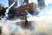 Un grupo de personas se enfrenta a la policía antidisturbios, este viernes, en la Plaza Italia en Santiago de Chile durante una nueva jornada de protestas en contra del gobierno del presidente Sebastián Piñera.-EFE / ELVIS GONZÁLEZ