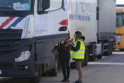 Dos operarias conversan con un transportista en el Centro de Transportes de Burgos.-RAÚL G. OCHOA