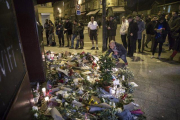 Los parisinos dejan flores y velas en honor a las víctimas de los atentados, en el café Carillon, en París.-EFE