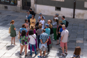 Un grupo de turistas escucha la explicación de una guía de la ciudad.