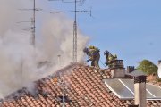 Dos bomberos intervienen desde la cubierta del edificio.