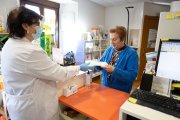 Una usuaria recoge la medicación semanal en la farmacia rural de Valdeavellano de Tera (Soria).