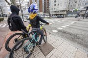 Dos jóvenes, en la avenida Cantabria, esperando a cruzar por un paso ciclista.
