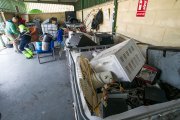 Un usuario y un trabajador con varios objetos para depositar en una zona destinada a electrodomésticos.