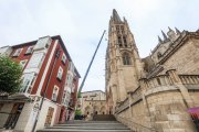 La grúa instalada en la plaza de Santa María traslada el yugo del campanario tras su arreglo.