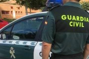 Archivo - Imagen de archivo de un agente de la Guardia Civil ante un coche patrulla.