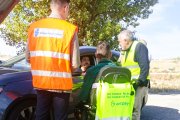 Pedro de la Fuente conversa con un conductor en las afueras de Burgos, en compañía de uno de los voluntarios de Aspaym para esta campaña.