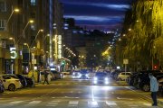 Un peatón cruza la avenida Reyes Católicos de noche, ya con el alumbrado público encendido.