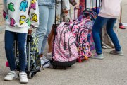Un grupo de niños y niñas esperan para entrar al colegio.