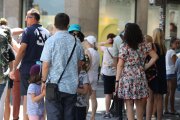 Archivo - Un grupo de gente espera a la sombra para cruzar un paso de peatones en la Gran Vía de Madrid.