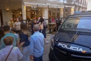 El detenido es conducido al furgón esposado y custodiado.