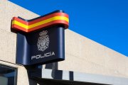 Archivo - Colores de la bandera de España envueltos en el logo de la policía en una comisaría.