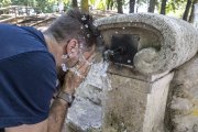 Un hombre se refresca en una fuente.