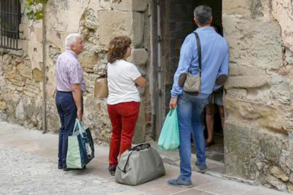 Tres visitantes esperan a la entrada de una casa rural.-ECB