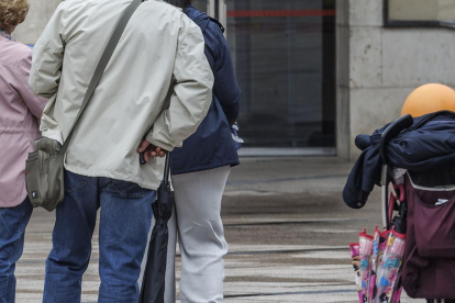 Una pareja de jubilados y una mujer de mediana edad frente al Ayuntamiento de Burgos.