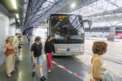 Un grupo de personas espera la llegada de su autobús en la estación de la calle Miranda