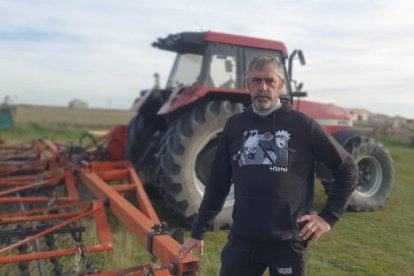 Félix posa con una almohaza o grada de púas flexibles con la que mantiene a raya las malas hierbas en el cereal