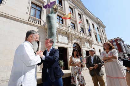 El artista Óscar Martín y el presidente de la Diputación, Borja Suárez, se saludan a los pies de la escultura.