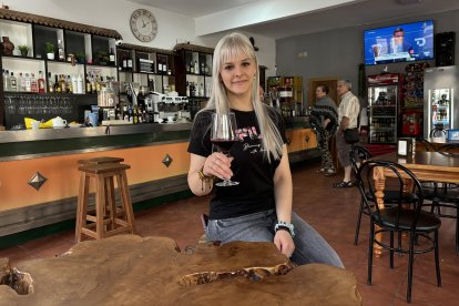 Dana posa junto a la mesa de madera de roble que ha fabricado su padre