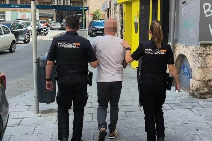 Dos agentes, con uno de los dos detenidos.