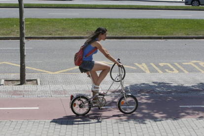 Una mujer circula por el carril bici.
