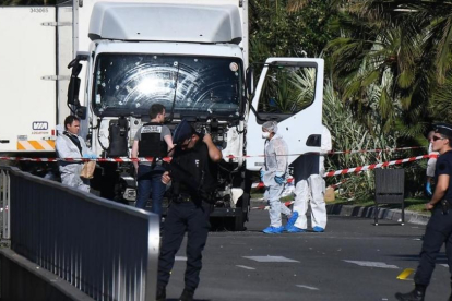 Forenses y policías buscan pruebas en el camión que arrolló a la multitud en Niza, este viernes.-AFP / ANNE-CHRISTINE POUJOULAT