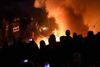 Manifestantes ante la policía en Barcelona.-AFP / LLUÍS GENÉ