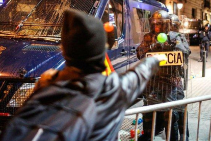 Un manifestante lanza una pelota a un policía, este sábado junto a la jefatura de Via Laietana-