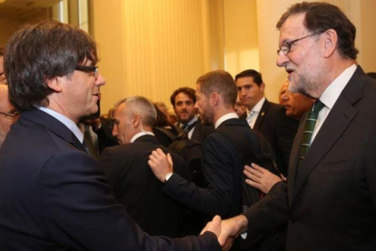 Puigdemont y Rajoy se saludan en el acto de inauguración de una exposición sobre Joan Miró en Oporto, el pasado septiembre.-ARCHIVO / JORDI BEDMAR