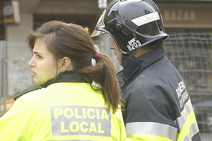 Una policia local y un bombero, durante una intervención.-ISRAEL L. MURILLO