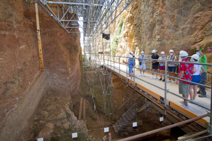 Un grupo de turistas atiende las explicaciones del guía frente al yacimiento de SIma del Elefante en Atapuerca, donde apareció la cara del primer europeo.