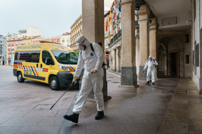 Personal municipal con mascarillas desinfectando los accesos al Ayuntamiento. ECB