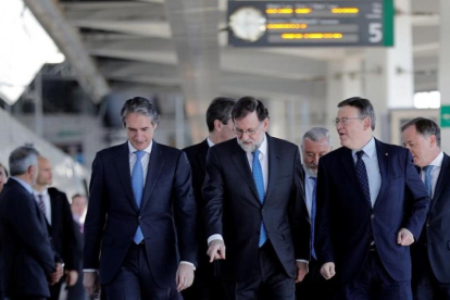 Mariano Rajoy, entre el ministro de Fomento, Íñigo de la Serna (izquierda en la foto), y el presidente de la Comunitat Valenciana, Ximo Puig, en la estación Joaquín Sorolla de Valencia antes de la salida hacia Castellón.-EFE