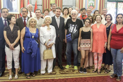 Foto de familia de los emigrantes retornados a la ciudad junto con las autoridades que les recibieron en el Salón de Plenos del Ayuntamiento.-SANTI OTERO