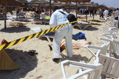 Un policía examina a dos víctimas del ataque terrorista en uno de los hoteles de Susa, en Túnez, el pasado 26 de junio.-Foto: STR / EFE
