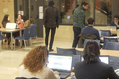 Jóvenes estudiantes con sus ordenadores portátiles en la biblioteca de la Universidad de Burgos.-ISRAEL L. MURILLO