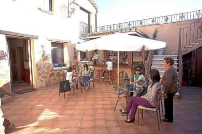 Un grupo de viajeros descansa en el patio de un alojamiento de turismo rural de Valladolid. Horizontal