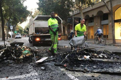 Una brigada de limpieza, en la calle de Consell de Cent con Pau Claris.-JOAN CORTADELLAS