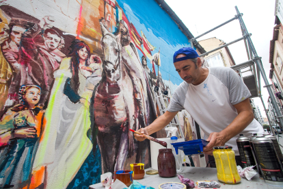 Uno de los artistas trabaja en el mural. TOMÁS ALONSO