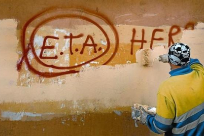 Un técnico de limpieza borra una pintada a favor de ETA en Gernika (Vizcaya), el día después de que la banda terrorista anunciase el cese definitivo de sus acciones armadas.-/ REUTERS / VINCENT WEST