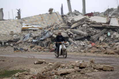 Un hombre circula en moto por los alrededores de Alepo.-KHALIL ASHAWI / REUTERS