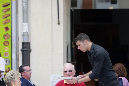 Un camarero atiende una mesa en una terraza de Burgos. El paro en el sector Servicios es el que más baja.-RAÚL OCHOA