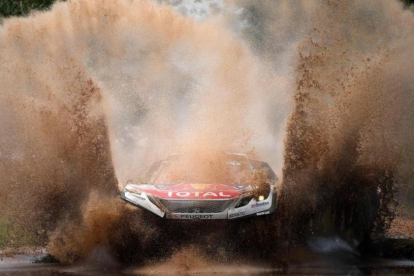 Sebastien Loeb (Peugeot) atraviesa un charco en la etapa de hoy del Dakar.-AFP / FRANK FIFE