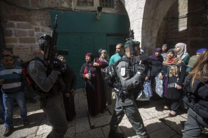 Agentes de policía israelís caminan junto a un grupo de mujeres palestinas en Jerusalén.-APC (EFE / ATEF SAFADI)