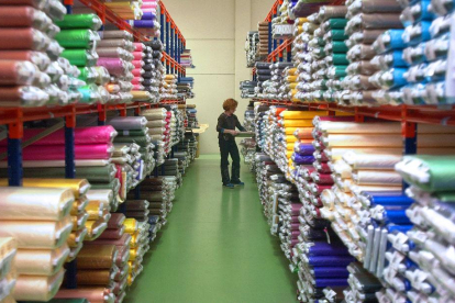 Una mujer coloca una tela en una fábrica de tejidos.-ISRAEL L. MURILLO