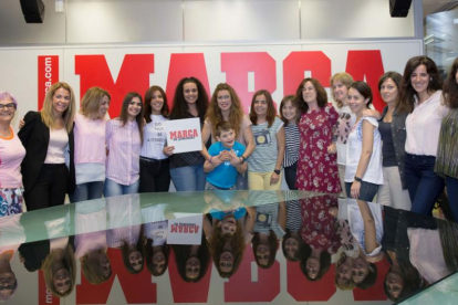 El pequeño Izan posa con los profesionales de la información deportiva que este año han querido colaborar en el calendario realizado para reunir fondos.-SERGIO PEÑA