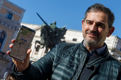 Alberto Luque posa con la aplicación en su teléfono al los pies del Cid Campeador. ECB